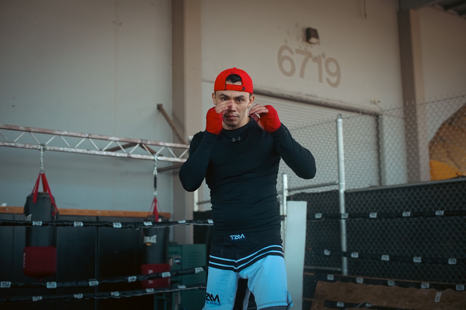 Boxer in gloves standing in a gym doorway
