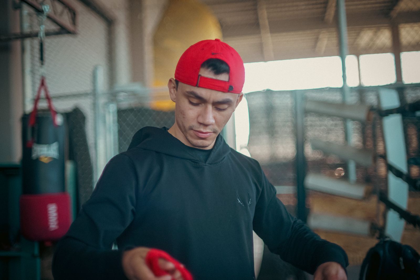 Fighter in a red cap taping up before a session