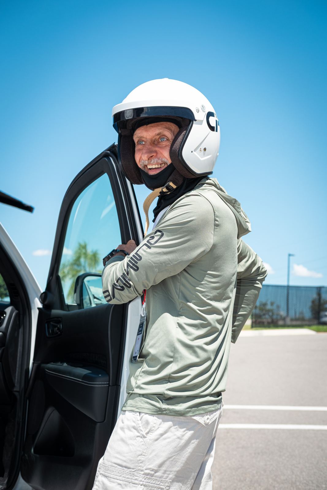 Driver in a white helmet stepping out of the car