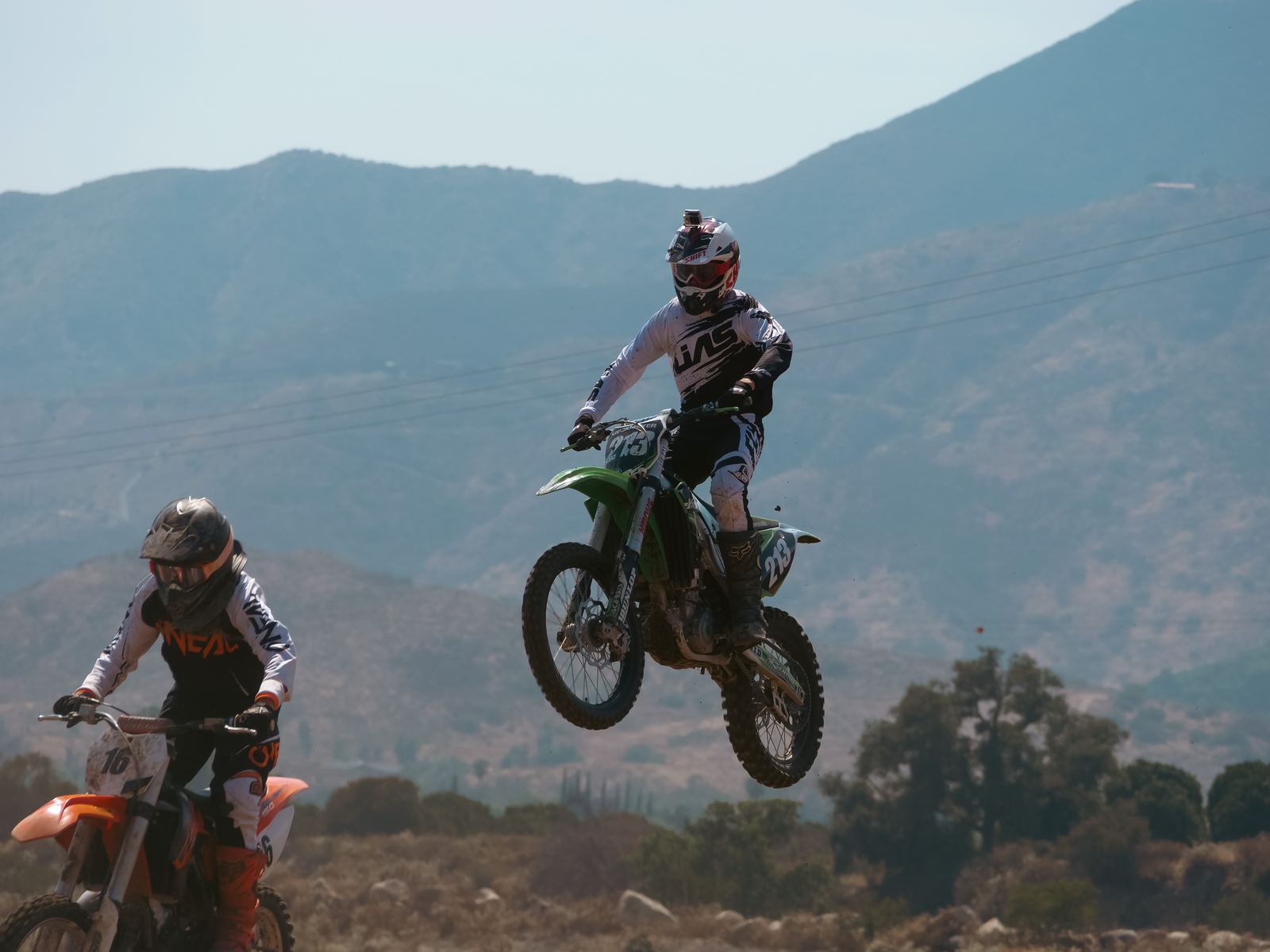 Two motocross riders jumping in sequence