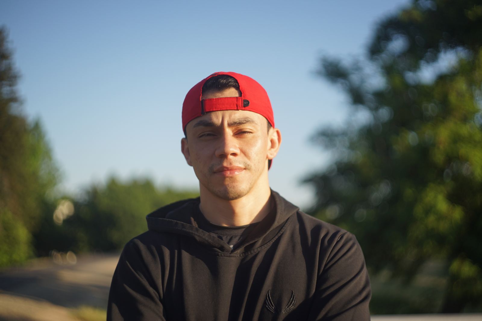 Golden-hour portrait of a young man in a red cap