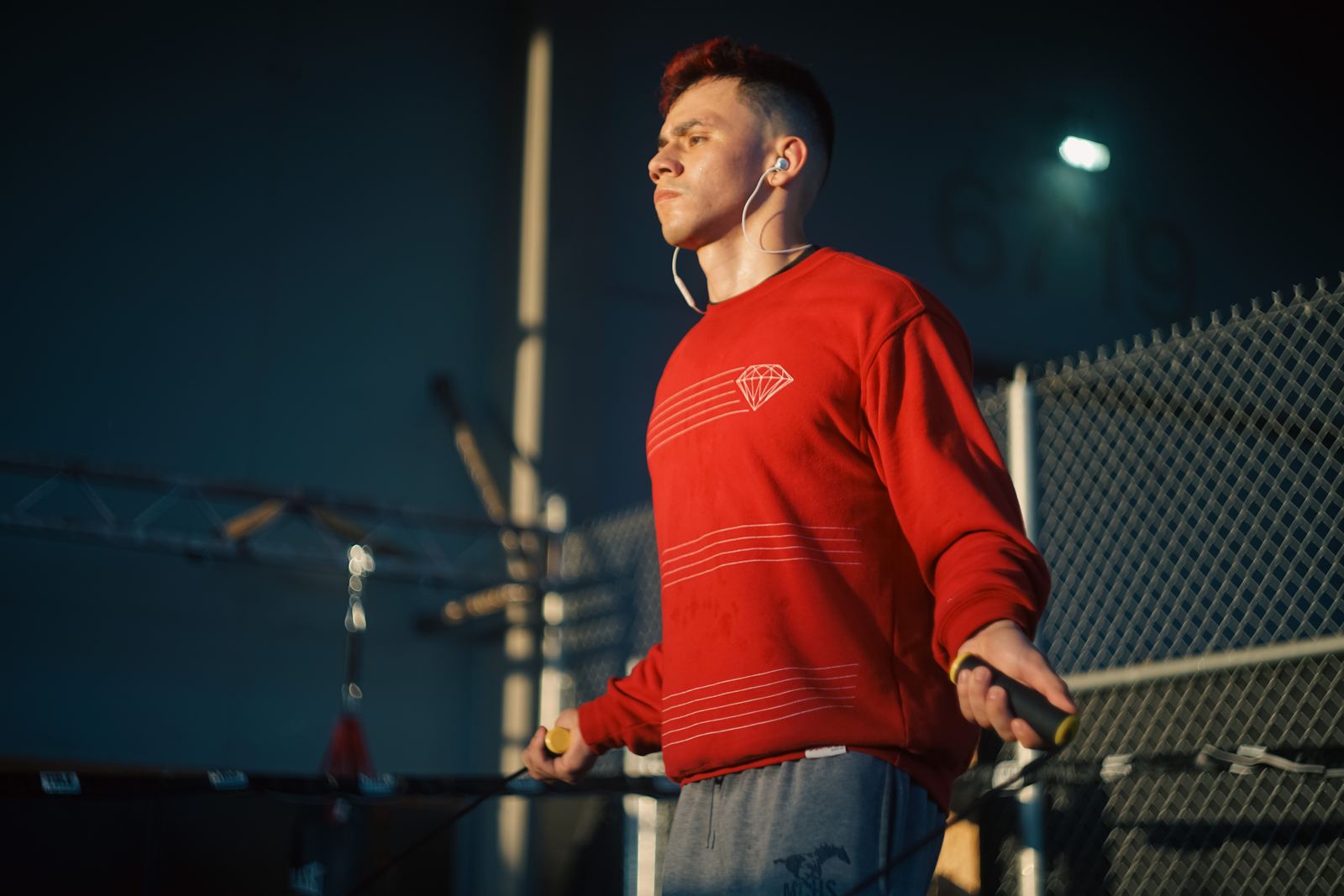 Man in a red sweater lit by a single street light