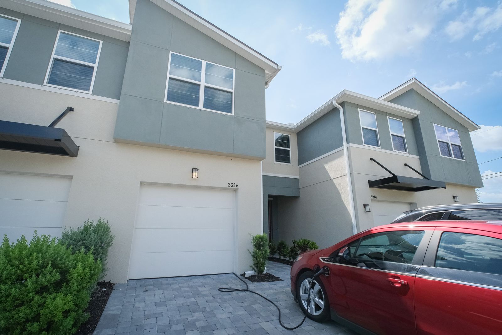 Townhome exterior with a garage under blue sky