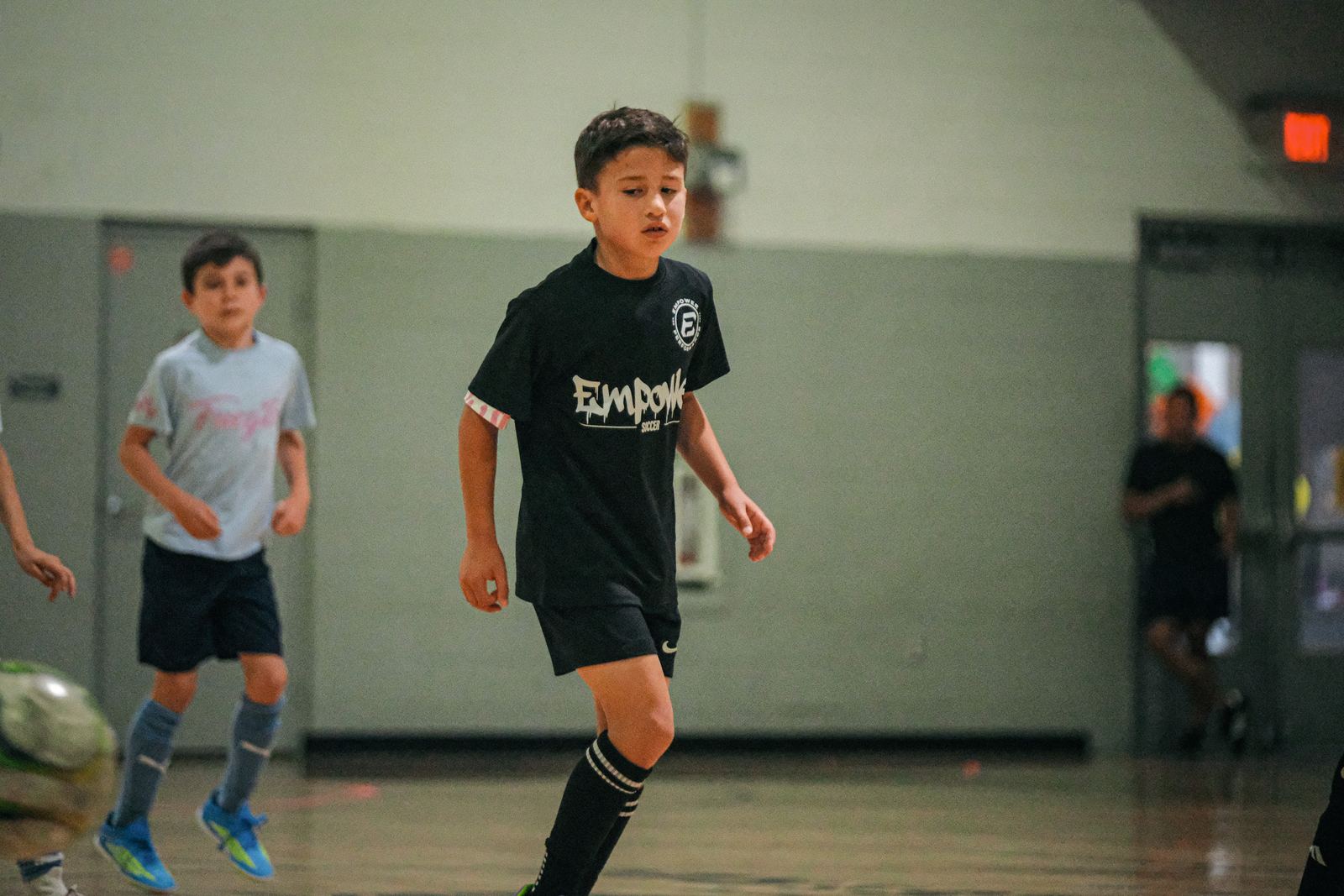 Young soccer players running onto the court