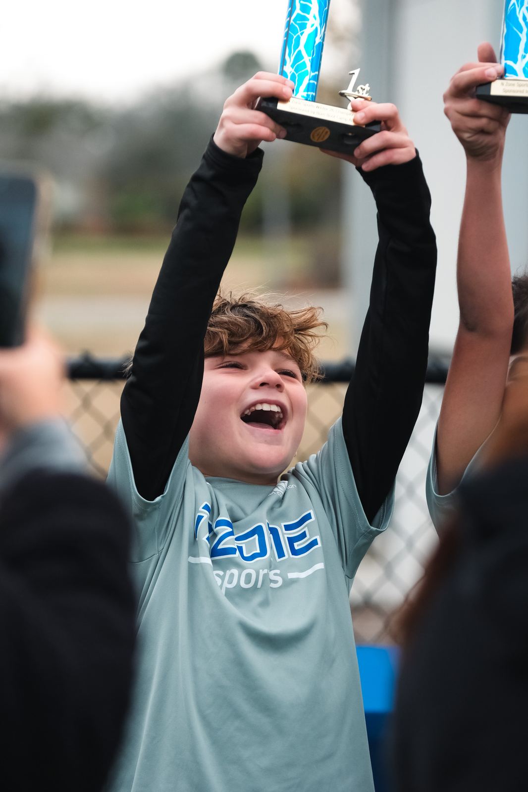 Young player lifting a trophy overhead after a championship